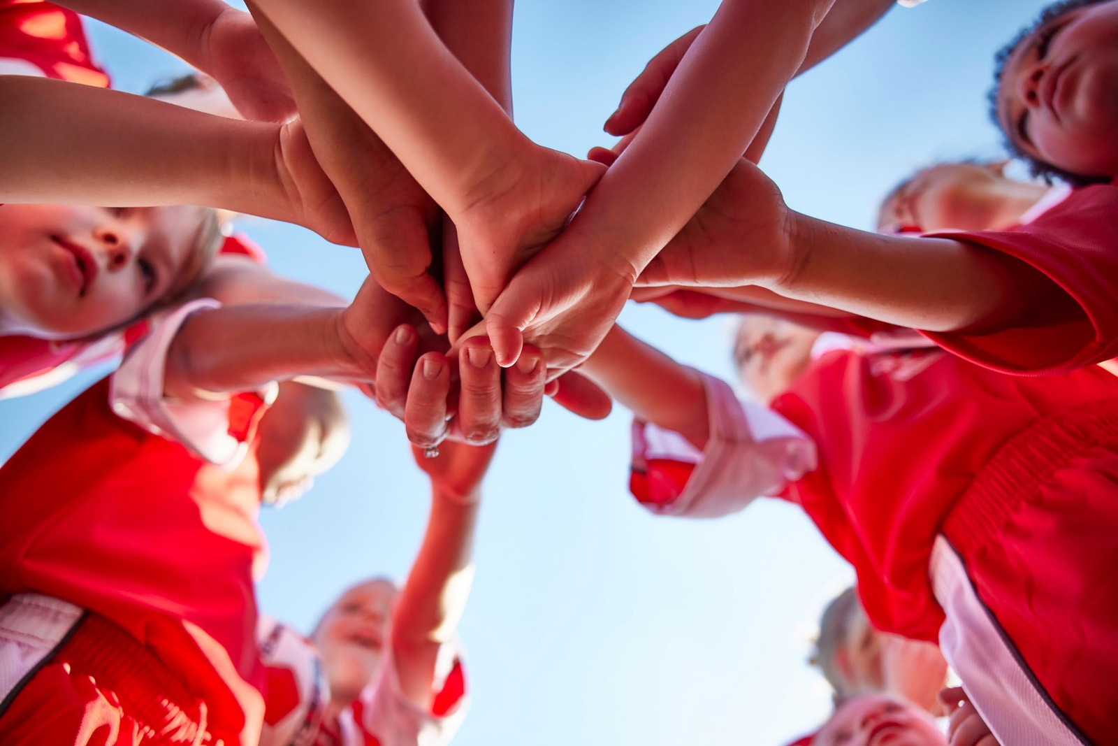 Niños uniendo manos en equipo