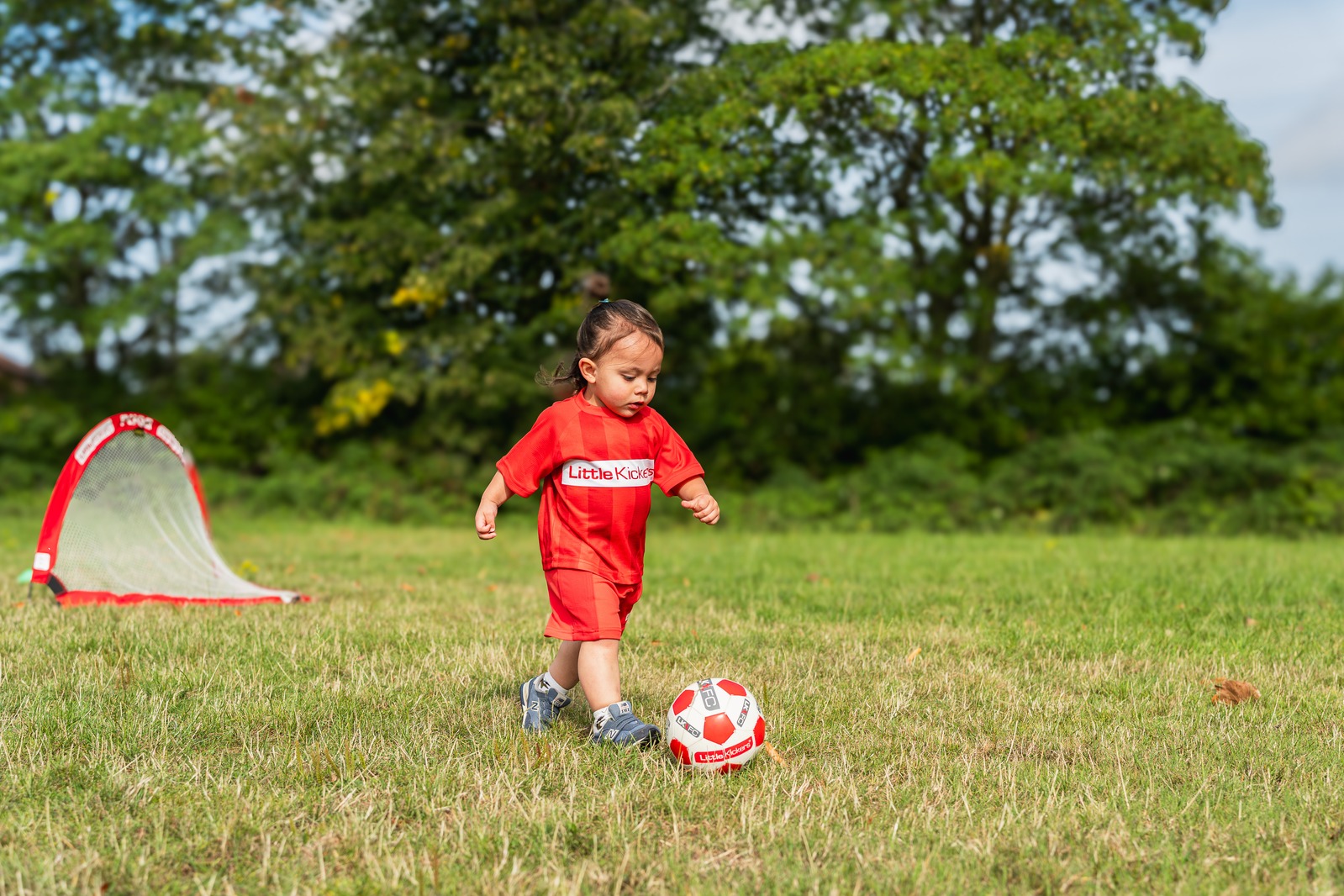Pequeña pateando balón en clase